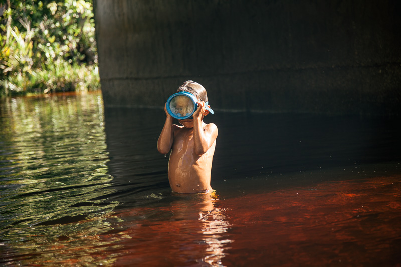 Photo Cubean indians paint themselves with carayuru in Vaupés. Right, a small indigenous boy plays with a mask in a stream in Puerto Inirida, Guaínia. 