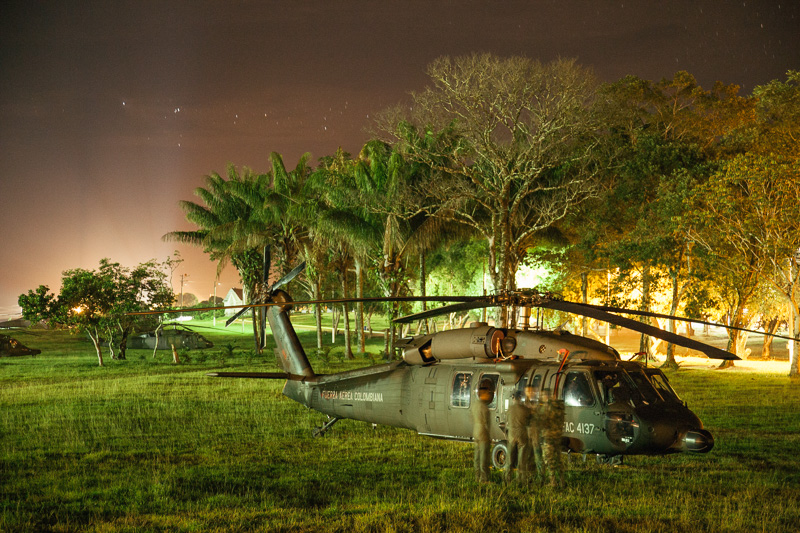 Photo On a military base down in the jungle, air force pilots put the Blackhawks to bed, whilst back up in the capital the evening