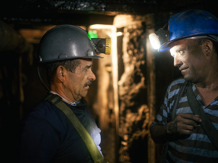 Photo The explosives engineer (left) talks to a miner while waiting for the charges to blow, in the La Paz mine, Cozcuez. 