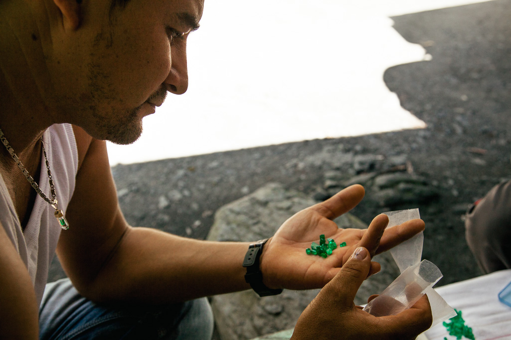 Photo A local trader inspects a handful of emeralds. 