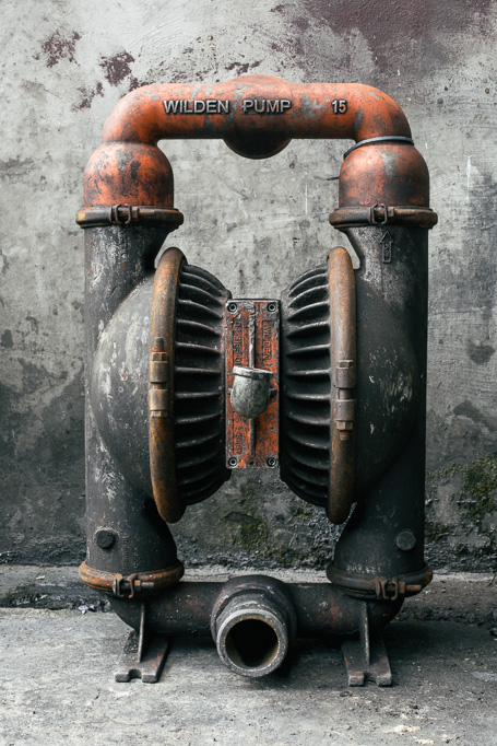 Photo Left, a welder in his red heat proof cape. Right, a water pump.